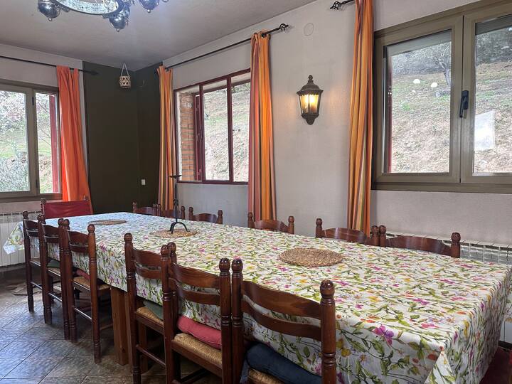 Comedor 1 con gran mesa junto al ventanal: comidas de grupo con vistas al bosque.