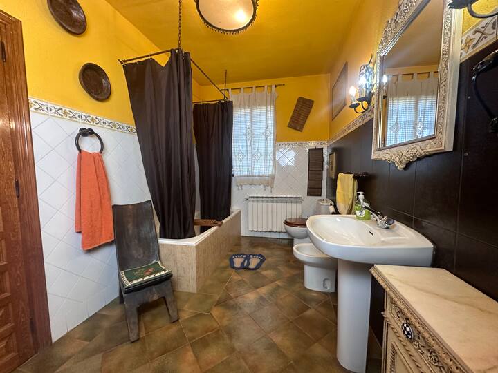 Baño completo 1 con bañera, lavabo de pie y ventana: luminoso y bien equipado.