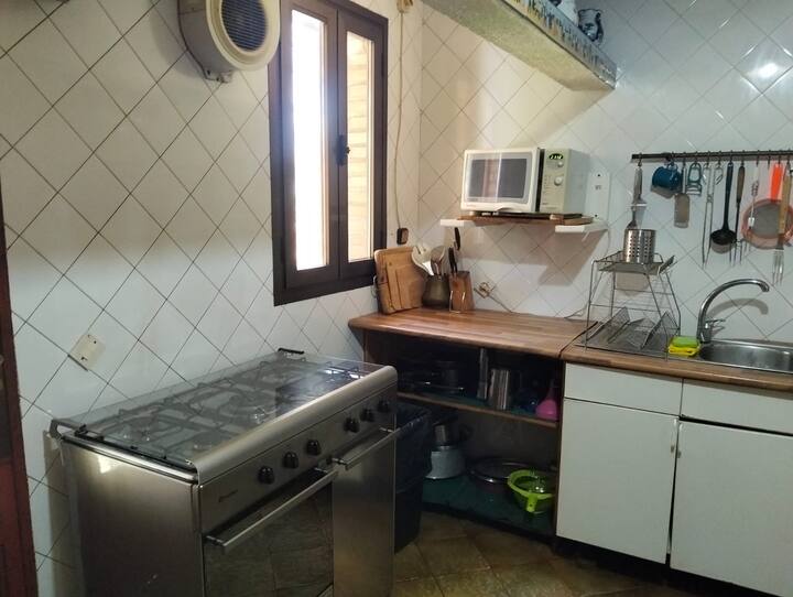 Cocina con horno de acero, fregadero y ventana: amplia y totalmente equipada.
