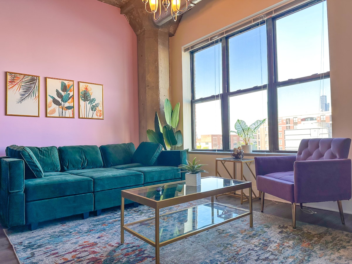 Ruime woonkamer met veel natuurlijk licht en grote ramen.