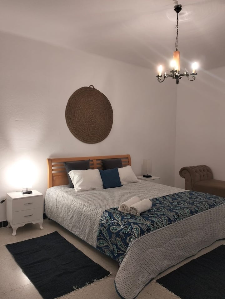 Large bedroom with a king size bed 170x200, crib with barrel, iron and ironing table, black-out curtain and window with screen.