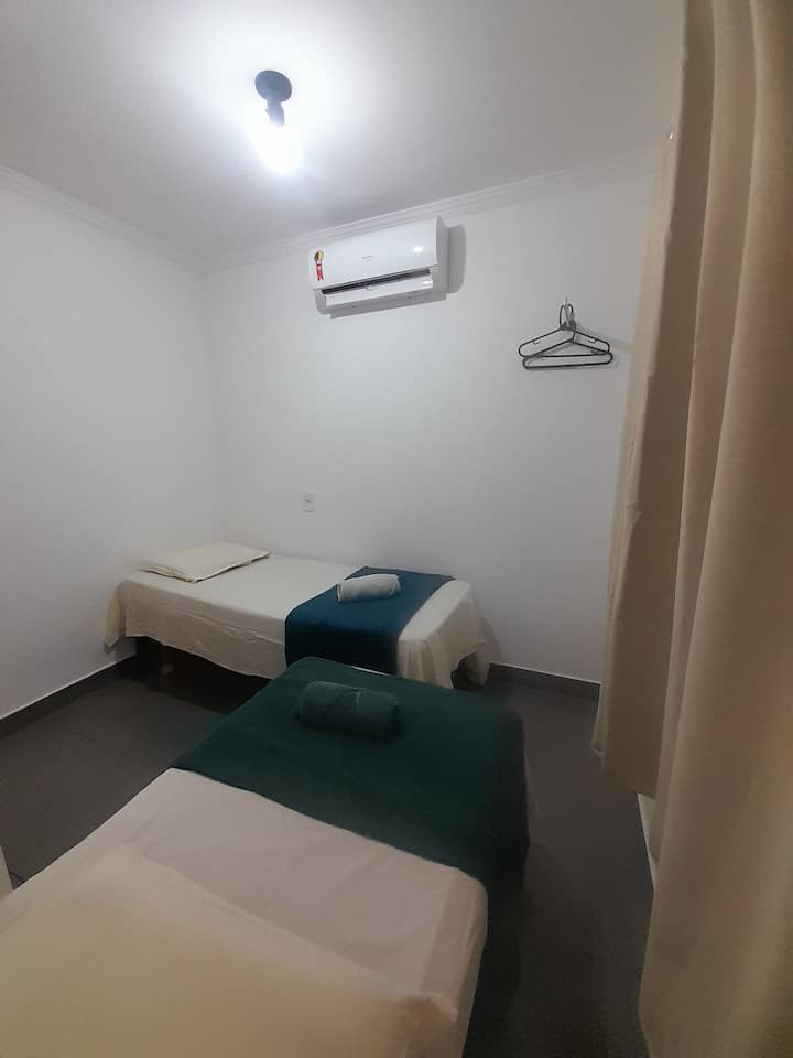 Chumba cha kulala chenye vitanda viwili vya mtu mmoja vilivyo na mashuka ya pamba na foronya, mataulo na mablanketi, kiyoyozi na dirisha lenye kitambaa cha kuzuia mwangaza.