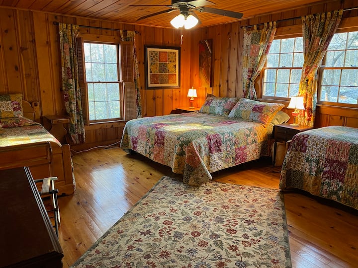 Esta espaciosa habitación cuenta con una cama tamaño king flanqueada por dos camas individuales. 