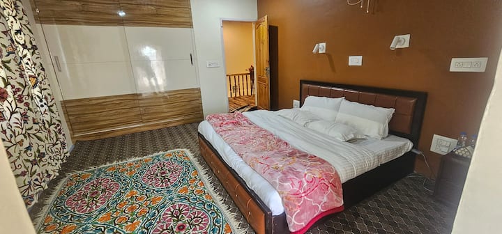 Entre em um refúgio de serenidade em nosso quarto espaçoso, onde cada detalhe sussurra o charme da Caxemira. 
Relaxe em nossa cama king size, perfeita para um sono tranquilo após um dia de exploração. Aquecedores de ambiente eficientes garantem conforto, mantendo você aconchegante.