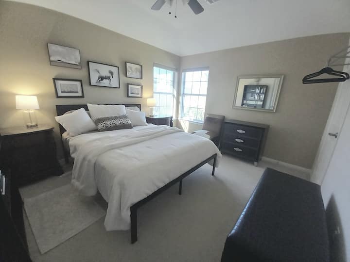 舒适的标准双人床，配备高密度泡沫床垫。  四间卧室之一，配有床头柜、床头充电站、梳妆台、衣架、书架。