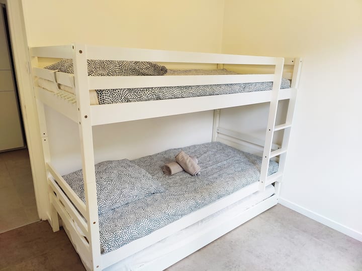 Soba s krevetima na kat postaje dječji kutak za igru i jednostavno i udobno utočište za goste. Prostor osmišljen za slatke snove, smijeh i blagdanske uspomene.