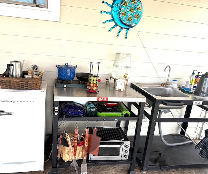 SHARED The covered outdoor kitchen on our home porch shared with guests with Frigidaire fridge, stainless dishwashing cold sink, electric convection toaster oven, propane stoves, v