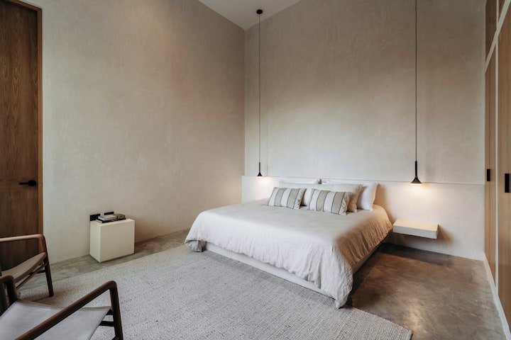 Dormitorio principal con techos de 25 pies, sonos, cama tamaño king con sábanas, persianas opacas, aire acondicionado, un montón de espacio en el armario, caja fuerte personal y la mejor vista que puedas imaginar.