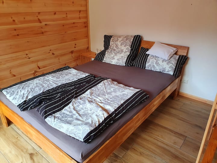 Posteľ pre hostí je  140 cm široká a 200 cm dlhá. Nachádza sa oddelene od obývacej izby a je oddelený veľkou drevenou poličkou. Priestor je otvorený do obývacej izby apartmánu.