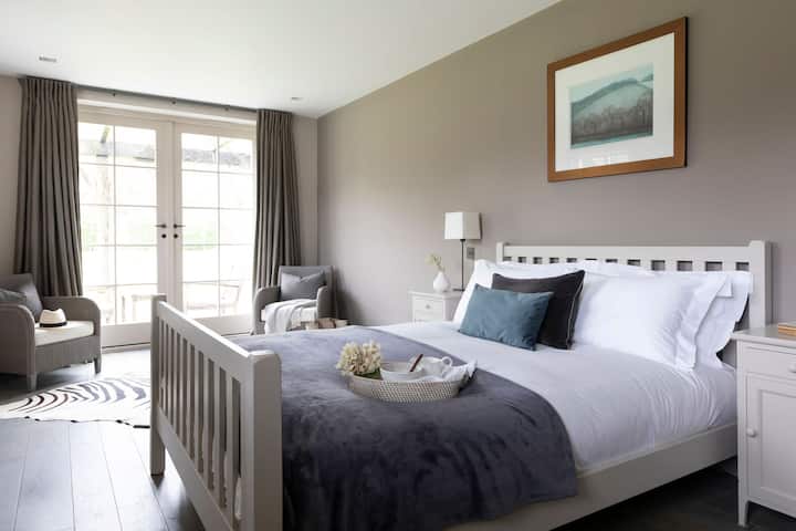 Bedroom with french patio doors leading onto the decking with garden views.