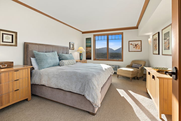Chambre avec lit King Size, vue sur la forêt et linge de maison de luxe.