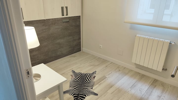 Chambre avec un lit de 90, placard et bureau ou bureau. 