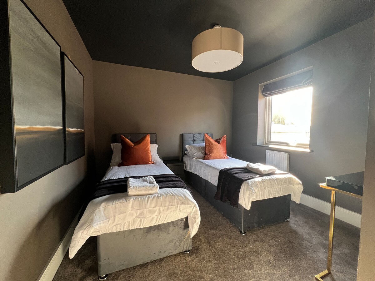 Simple elegance and comfort: a serene bedroom with single beds, adorned with plush pillows and soft bed linens for a restful retreat.