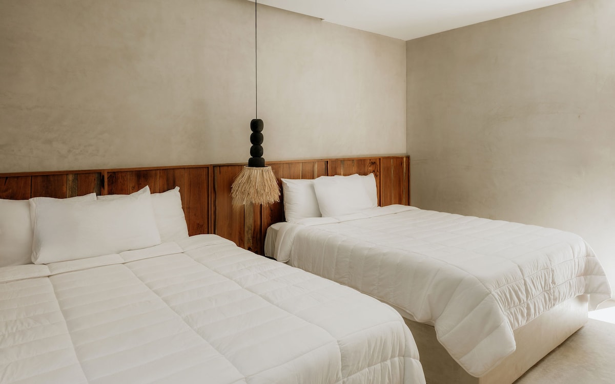 Two queen beds ideal for group travel, friends, or children, with direct pool access and a TV for comfort and entertainment.