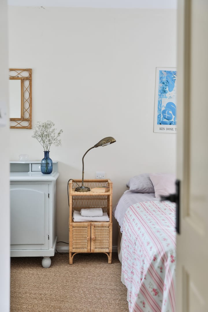 This bedroom has an en-suite, a king sized bed and windows on both sides with views down into the garden.