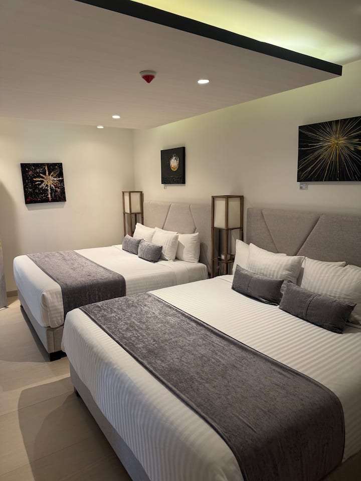 Gostinjska soba „King” – 2 bračna kreveta, pametni TV i kupaonica s WC-om koja je povezana s drugom sobom.