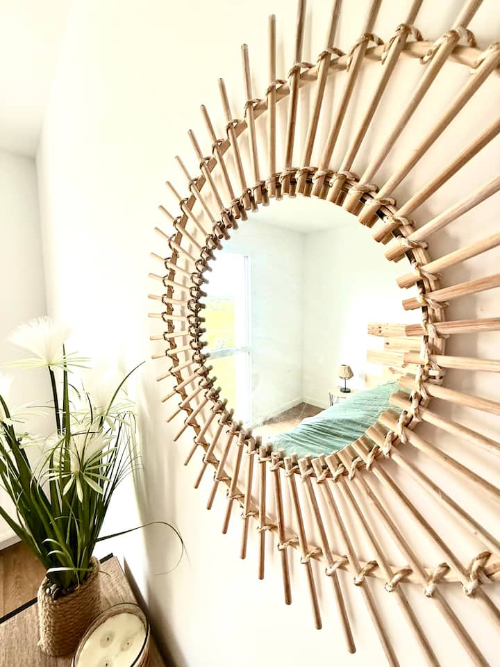 Un jeu de reflets dans l’œil du miroir, dévoilant la chambre sous un angle inédit, entre charme et perspective.