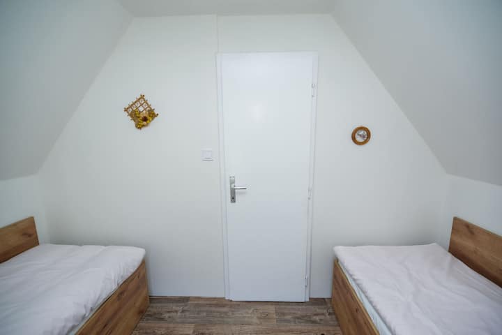 Dhoma ndodhet në katin e parë dhe është e pajisur me dy krevate dopio, hapësirë magazinimi.  