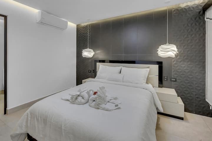 Lemur room, with comfortable sheets, pillows, and towels. Lighting around the entire room, with smart TV, closet, safe and private bathroom.