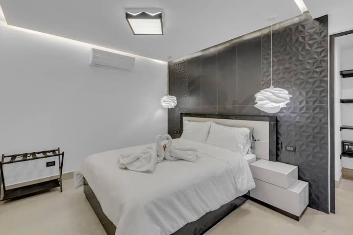 Panda  Room, with comfortable sheets, pillows and towels. Lighting around the entire room, with smart TV, a closet, safe and private bathroom.