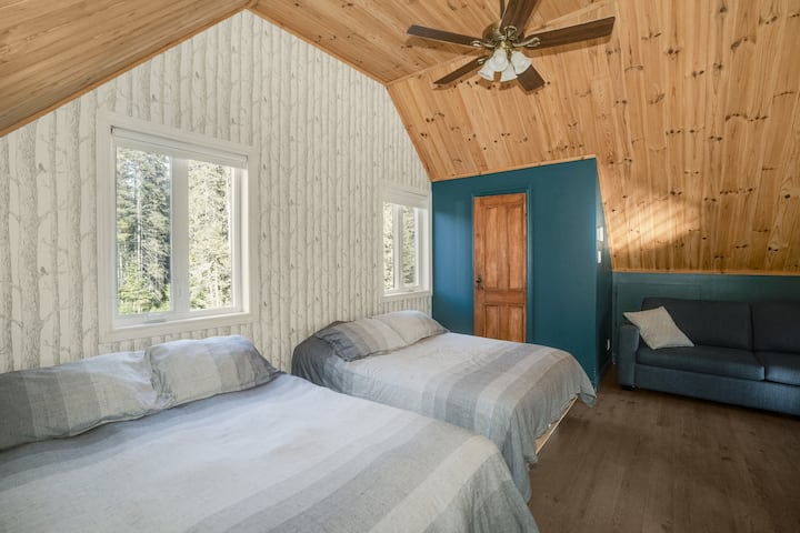 Comfortable bedroom with bright windows, offering a peaceful retreat.