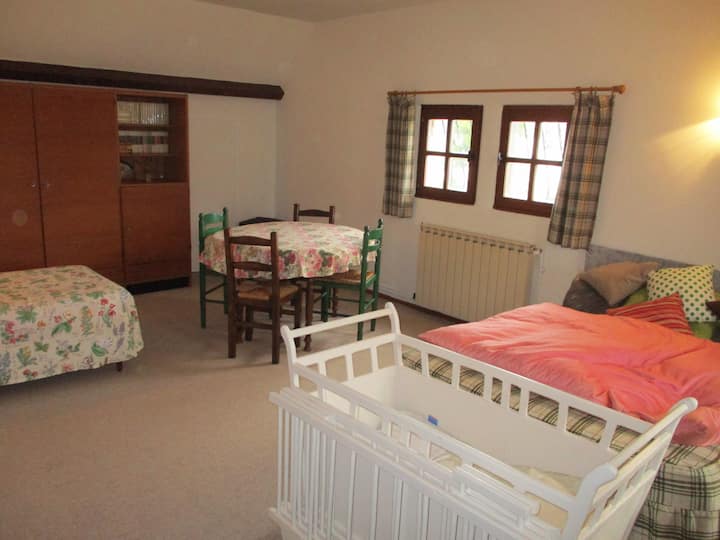 спалня 30 кв. м в детското легло на преден план, сгънат детски парк, на дясното двойно легло, лявото единично легло, на задната кръгла маса с 4 стола, които могат да се използват като офис зона.