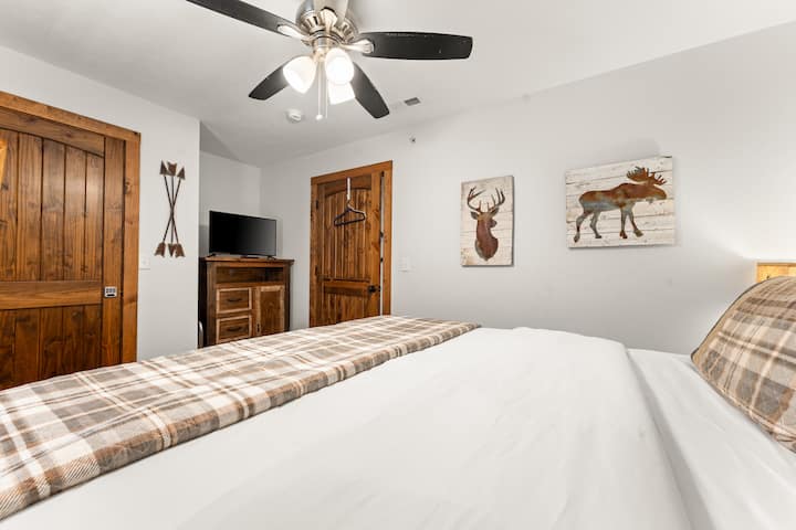 Spavaća soba s bračnim krevetom i pametnim televizorom. 