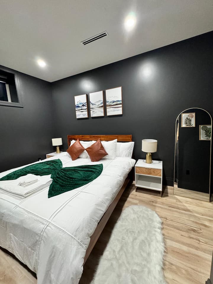 La habitación cuenta con un espejo elegante y con marco dorado de cuerpo entero, perfecto para prepararse, y una lujosa alfombra de piel sintética que agrega un toque suave y texturizado bajo los pies.