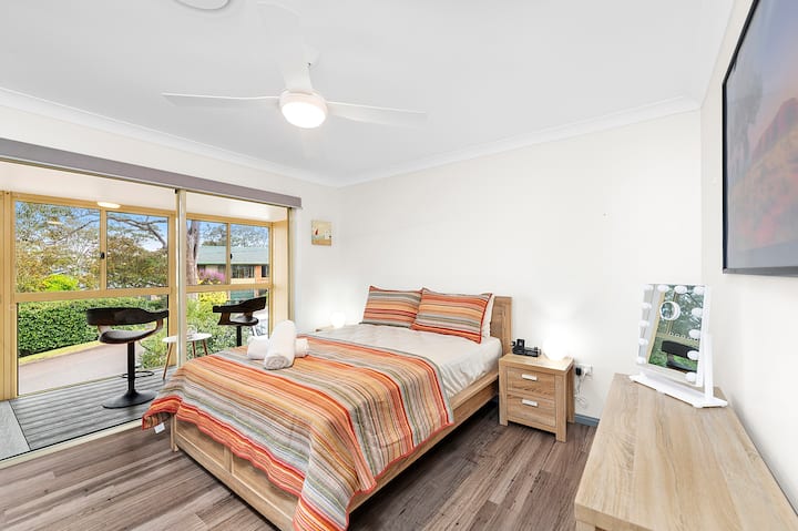 Master bedroom with sliding doors onto sunroom with water view. 