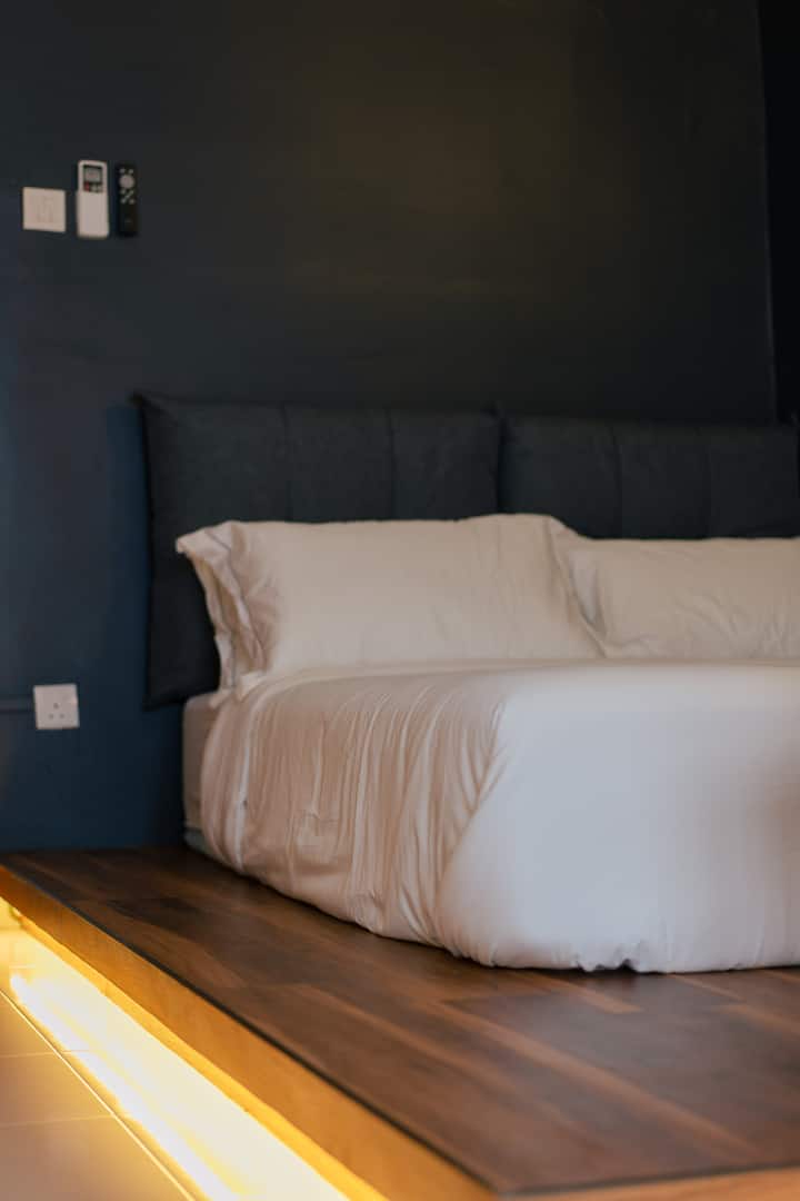 Sink into plush premium mattresses  from King Koil Luxury Hotel collection. Each bedroom comes fully air-conditioned with an attached bathroom. This common bedroom has an open clothes rack for hanging clothes.