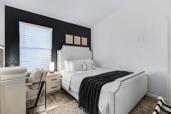 Stylish queen bedroom with plush bedding, a peaceful atmosphere, and a cozy retreat designed for restful nights and comfortable stays.