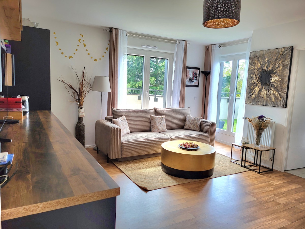 A comfortable living area is shown, featuring a striped sofa with decorative cushions and a circular coffee table. Natural light illuminates the space through large glass doors that provide access to the terrace. A piece of wall art complements the tasteful decor.
