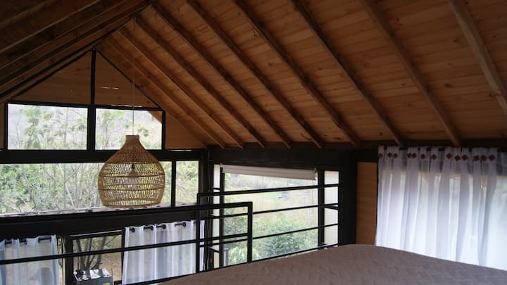 ชั้นลอยซึ่งเป็นที่ตั้งของเตียงคู่ที่อบอุ่นของเราให้สถานที่พักผ่อนที่เป็นกันเองล้อมรอบด้วยหน้าต่างที่มองเห็นสวน