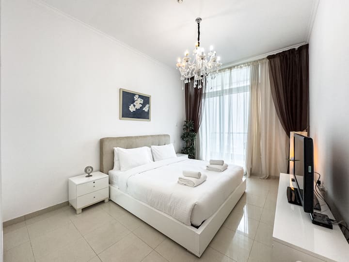  Amplio dormitorio tamaño king | Alojamiento en el puerto deportivo de Dubái: relájate en una cómoda cama tamaño king con sábanas suaves, cortinas opacas y ventanas del piso al techo.