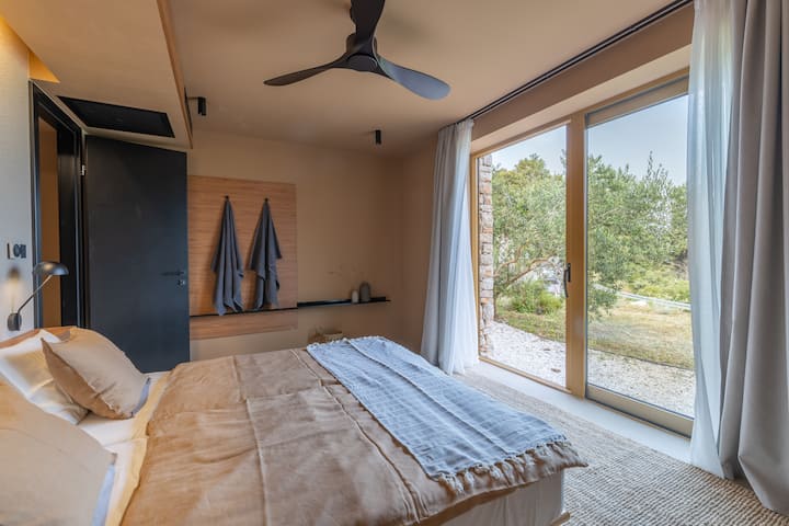 Spálňa 2 má výhľad priamo na more. Rovnako ako vo všetkých izbách má okrem praktickej nástennej police aj priestor na zavesenie uterákov a ďalších vecí.