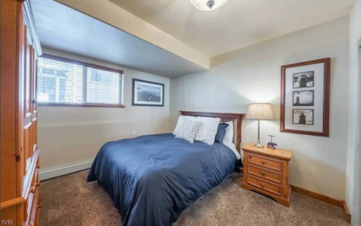 Dormitorio con cama queen, armario con TV y armario. Este dormitorio está ubicado en el nivel inferior de la casa.