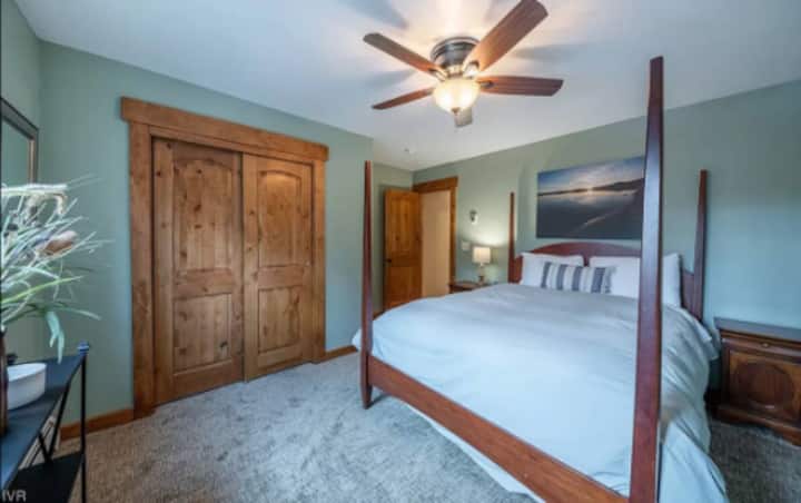 Dormitorio con cama tamaño queen, ventilador de techo y armario. Este dormitorio está en el nivel principal de la casa.