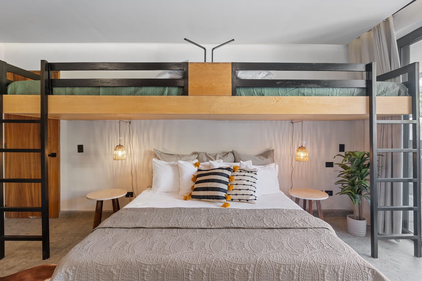 Let the kids take the loft bunk while parents get the king below. Pendant lights, good pillows, everyone wins.