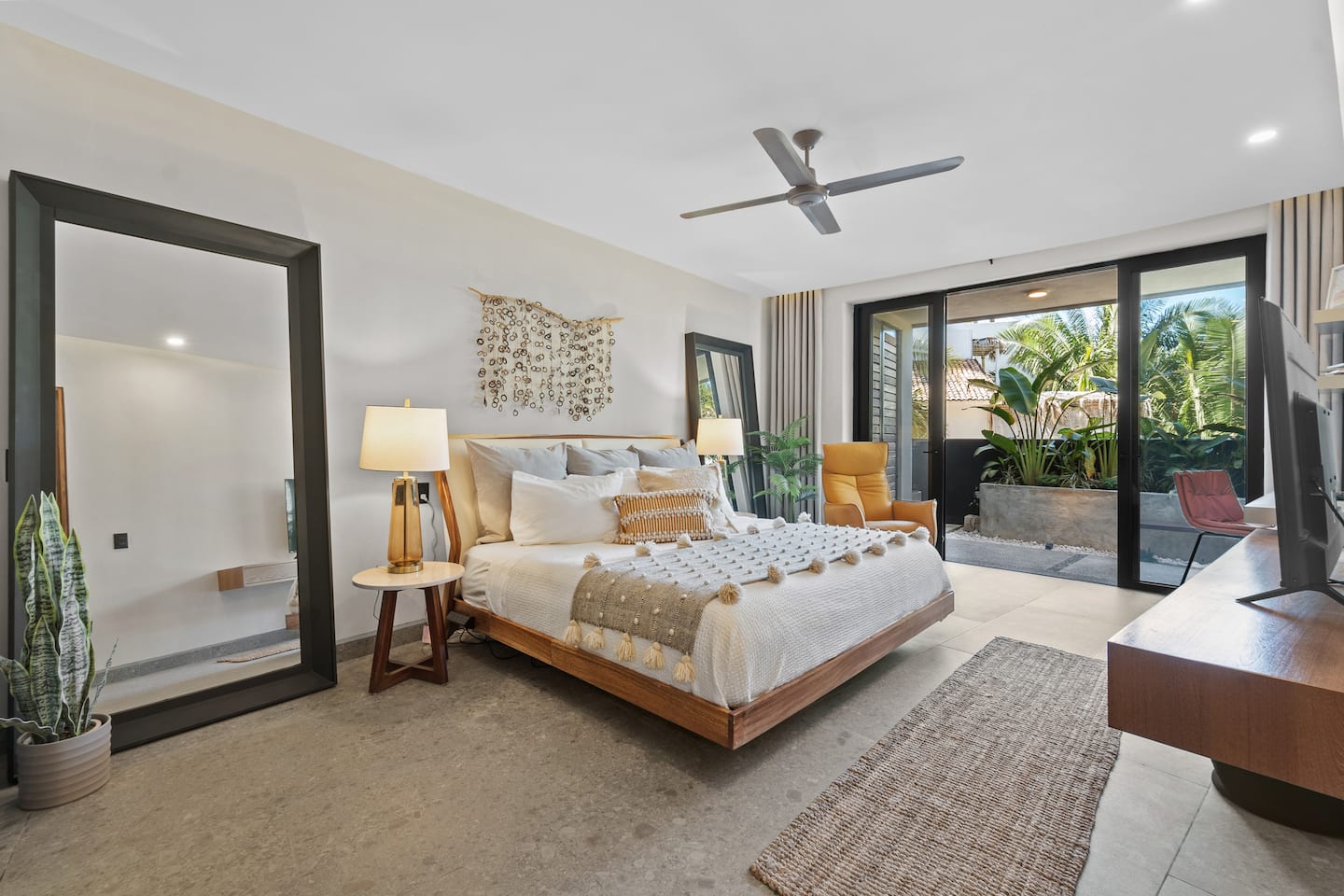 Your master suite: king bed, a chair to sink into, and the jungle right outside the glass.