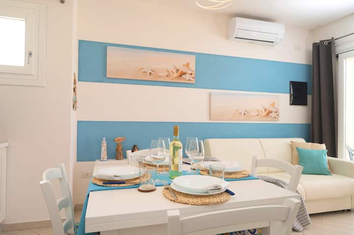 Sala de estar con cómodo sofá cama, mesa de comedor, TV de alta definición, aire acondicionado.