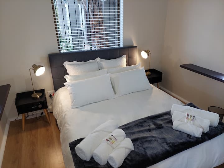 Cama tamaño queen con ropa de cama de algodón egipcio, mesitas de noche, luces de lectura, puertos de carga USB, secador de pelo, espejo de tamaño completo, persianas oscuras de la habitación