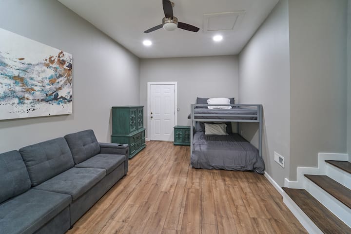 חדר קומתיים למעלה עם ספה נפתחת למיטה זוגית. הדלת מובילה לחצר האחורית. 