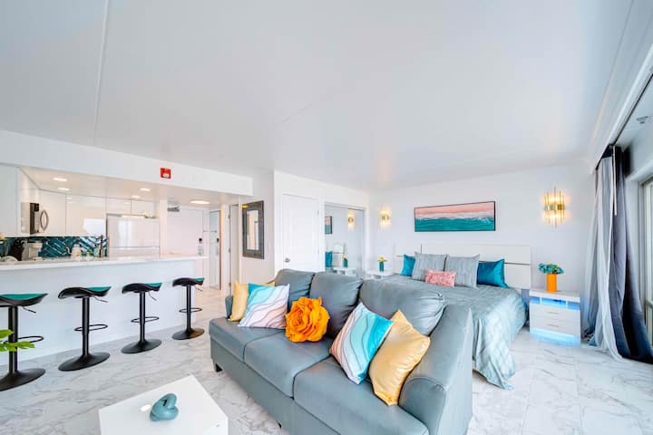 ห้องนั่งเล่นหรูกว้างขวางพร้อมทีวีศิลปะและโซฟาปรับนอนหนังควีนไซส์