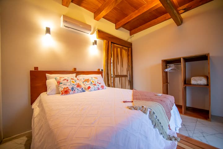 Queen bedroom with private bathroom and air conditioning.