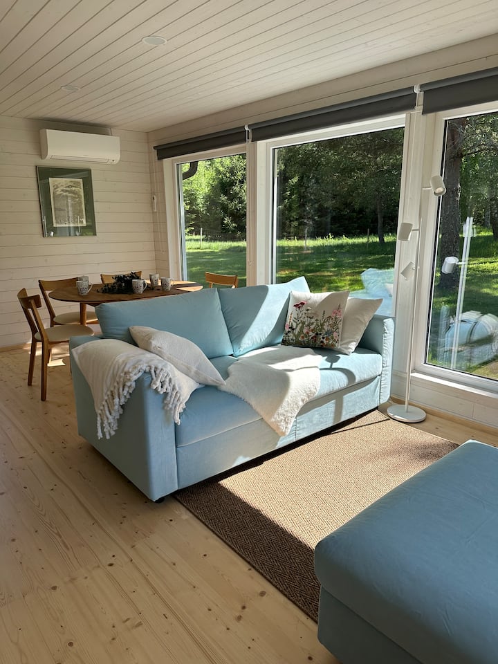 Le salon dispose de baies vitrées et d'un magnifique canapé convertible bleu marine avec un pouf. Le canapé-lit (140 cm) s'ouvre à l'avance et peut accueillir confortablement 2 personnes. Les stores occultants permettent à la pièce d'obscurcir complètement la pièce.