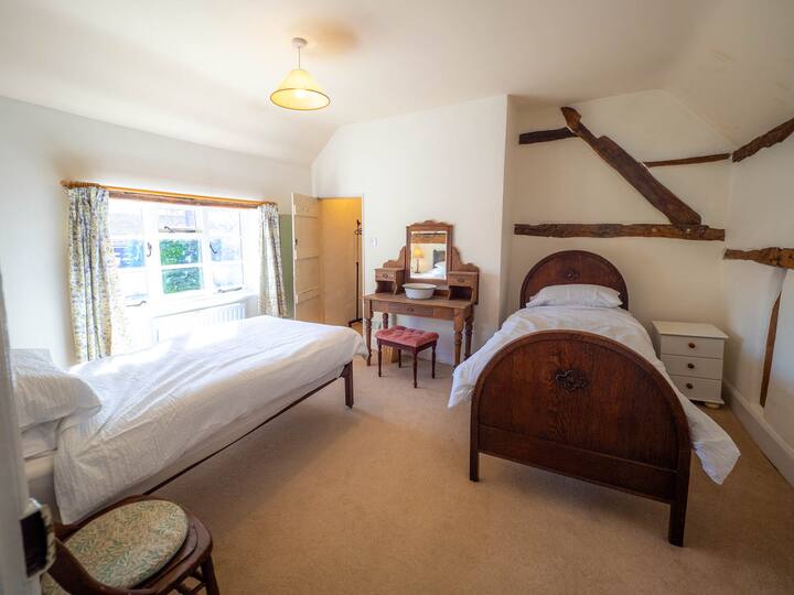 Šarmantna spavaća soba s dva udobna kreveta za jednu osobu. Idealno za prijatelje ili braću i sestre, nudeći udobnost i ugodnu atmosferu za miran san.