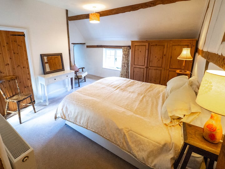 Prolazna spavaća soba s udobnim bračnim krevetom koja služi kao prolaz do dodatne spavaće sobe.