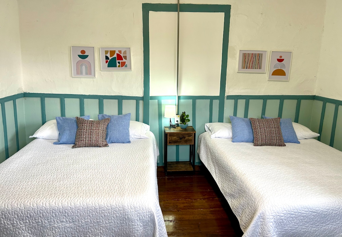 חדר מרווח עם שתי מיטות זוגיות.