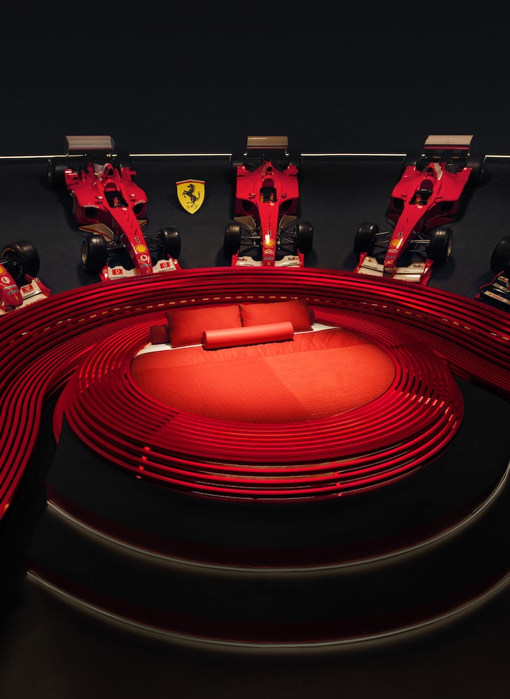 We introduced a bed at Museo Ferrari inspired by the surrounding racing cars.  Hand-sewn in this season's newest red.  The metal decoration in the room totals 3,000 m, the length of the Maranello race track. 