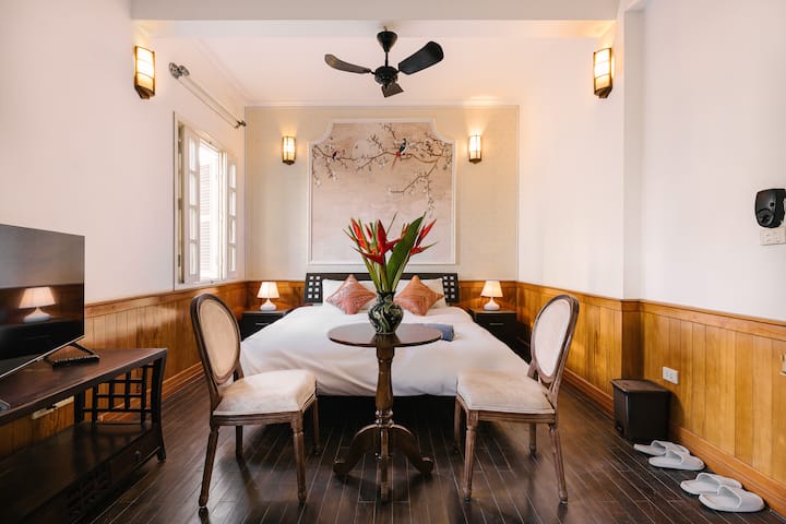 غرفة نوم أكبر وشرفة صغيرة. 
يوجد سرير كبير وخزانة ملابس وطاولة جانبية مع كرسيين وتلفزيون وثلاجة صغيرة وأثاث آخر. الحمام به حوض استحمام في الداخل.